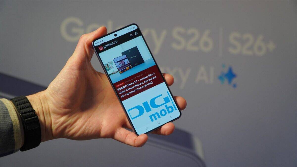 Telefon cu ecran afișând site-ul Gadget.ro, în fața unui background cu tehnologie și branding.